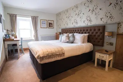 a bedroom with a large bed and a desk at The Royal Heysham in Heysham