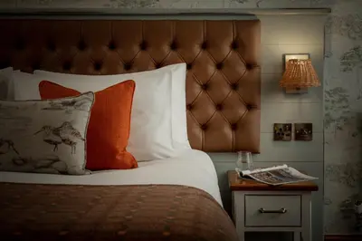 a bedroom with a bed and a night stand with a lamp at The Royal Heysham in Heysham