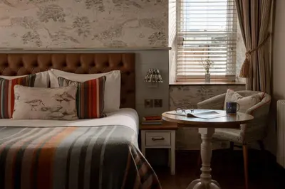 a bedroom with a bed and a table and a chair at The Royal Heysham in Heysham