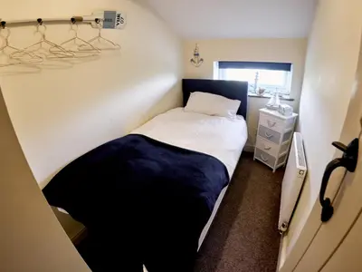 a small bedroom with a bed and a window at Tower View in Blackburn