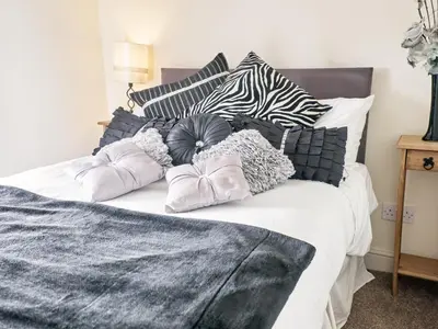 a bed with black and white pillows on it at Tower View in Blackburn