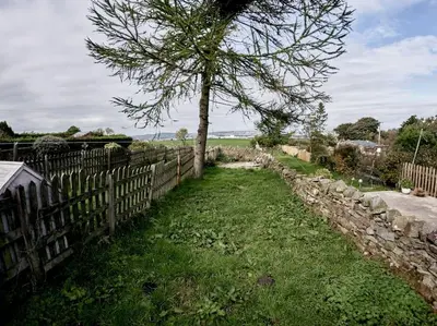 a tree in a yard next to a fence at Tower View in Blackburn
