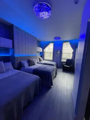 a hotel room with two beds and blue lights at 19 Rodney Street Apartments in Liverpool
