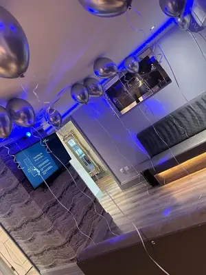 a room with a bar with blue lights and balloons at 19 Rodney Street Apartments in Liverpool