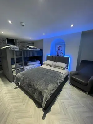 a bedroom with a bed and a couch and a chair at 19 Rodney Street Apartments in Liverpool