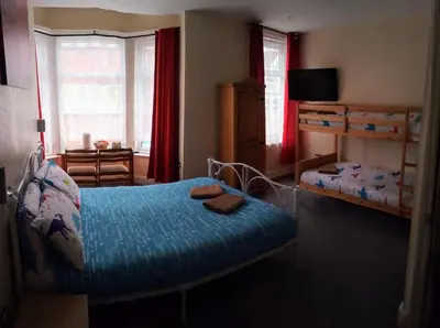 a bedroom with two beds and a bunk bed at Meland (Families ONLY B&B) in Blackpool