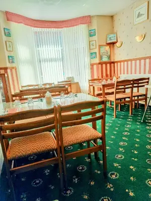 a dining room with wooden chairs and a table at Meland (Families ONLY B&B) in Blackpool