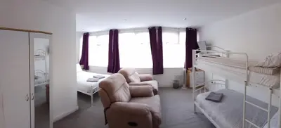 a bedroom with a bunk bed and a chair and a couch at Meland (Families ONLY B&B) in Blackpool