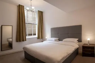 a bedroom with a large bed and a mirror at The Castle Collection - 25 Castle Street in Liverpool