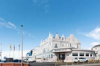 a white building with cars parked in front of it at Best Western Carlton Hotel in Blackpool