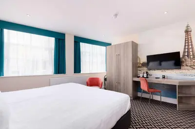 a hotel room with a bed and a desk and a tv at Best Western Carlton Hotel in Blackpool