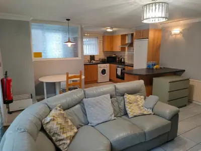 a living room with a couch and a kitchen at San Remo Apartments Blackpool in Blackpool