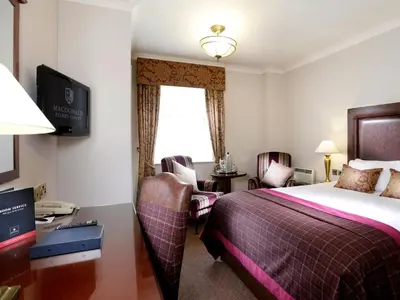 a hotel room with a bed and a desk at Macdonald Kilhey Court Hotel in Wigan