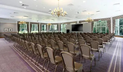 a large room with rows of chairs and a screen at Macdonald Kilhey Court Hotel in Wigan