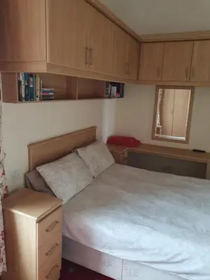 a small bedroom with a bed and wooden cabinets at Manhattan Lodge in Lytham St Annes