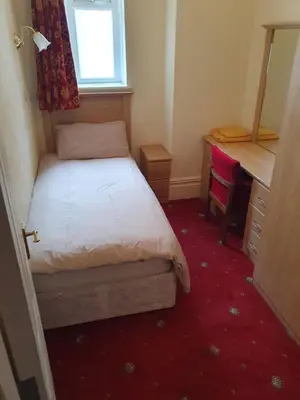 a small bedroom with a bed and a desk at Manhattan Lodge in Lytham St Annes