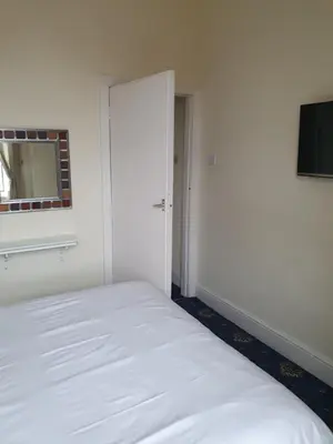 a bedroom with a white bed and a mirror at Manhattan Lodge in Lytham St Annes