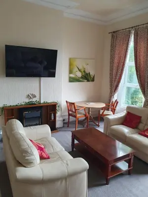 a living room with a couch and a table at Manhattan Lodge in Lytham St Annes