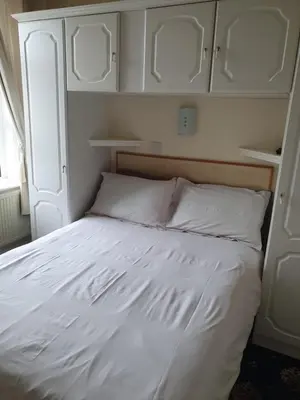a white bed in a bedroom with white cabinets at Manhattan Lodge in Lytham St Annes