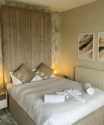 a large bed with two towels on top of it at The Commodore Inn in Grange Over Sands