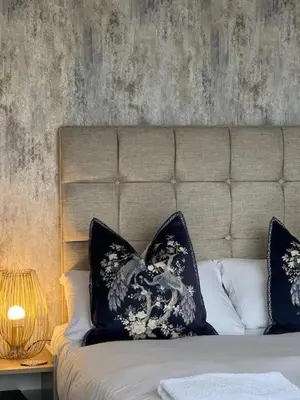 a bed with blue and white pillows on it at The Commodore Inn in Grange Over Sands