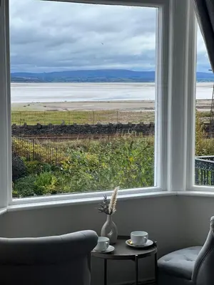a room with a window with a view of the ocean at The Commodore Inn in Grange Over Sands