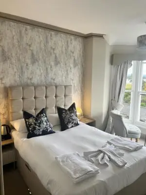 a bedroom with a large bed with towels on it at The Commodore Inn in Grange Over Sands