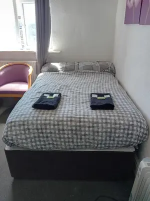 a bedroom with a bed with two towels on it at The Beckwood Hotel in Blackpool