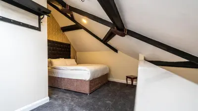a small room with a bed in a attic at Trivelles Seaforth in Bootle