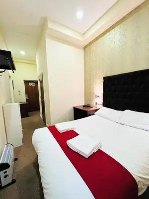 a hotel room with a large bed with a red blanket at Trivelles Seaforth in Bootle