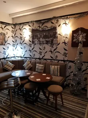 a restaurant with couches and tables and a christmas tree at Montgomery Hotel in Blackpool