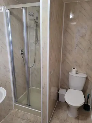 a bathroom with a shower and a toilet and a sink at Montgomery Hotel in Blackpool