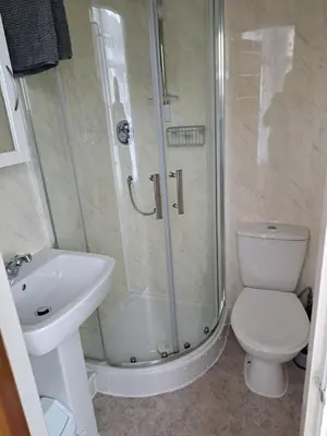 a bathroom with a shower and a toilet and a sink at Montgomery Hotel in Blackpool