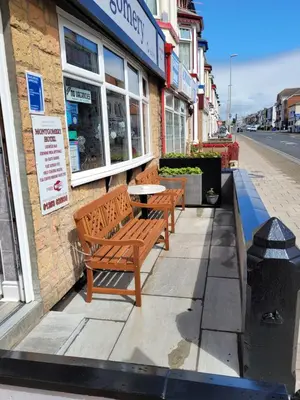 two benches on a sidewalk outside of a store at Montgomery Hotel in Blackpool