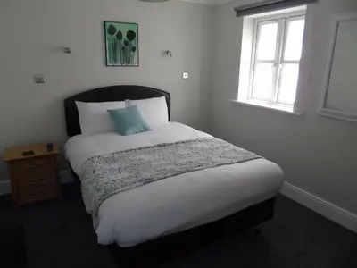 a bedroom with a large bed with a window at Jeffersons Hotel & Serviced Apartments - The Steel Works in Barrow in Furness