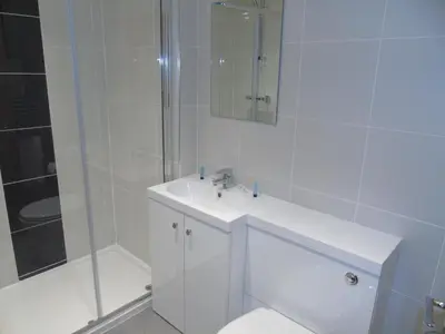 a white bathroom with a sink and a shower at Jeffersons Hotel & Serviced Apartments - The Steel Works in Barrow in Furness