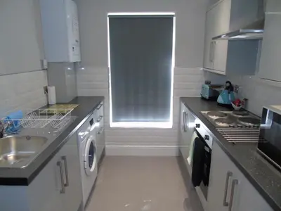 a white kitchen with a sink and a stove at Jeffersons Hotel & Serviced Apartments - The Steel Works in Barrow in Furness