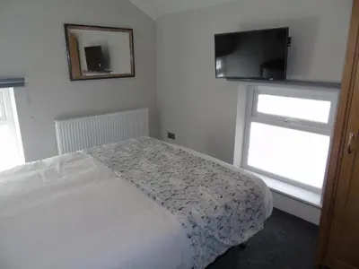 a bedroom with a bed and a flat screen tv at Jeffersons Hotel & Serviced Apartments - The Steel Works in Barrow in Furness