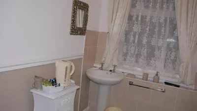 a bathroom with a sink and a toilet and a window at Hornby House Hotel in Blackpool