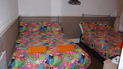 a bedroom with two beds with colorful blankets and pillows at Hornby House Hotel in Blackpool