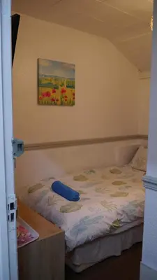a bed in a room with a painting on the wall at Hornby House Hotel in Blackpool