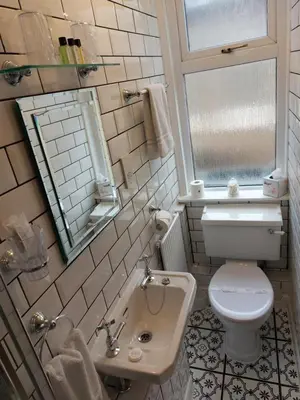 a bathroom with a toilet and a sink and a mirror at Westfield House in Blackpool