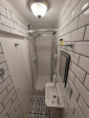 a white bathroom with a shower and a sink at Westfield House in Blackpool