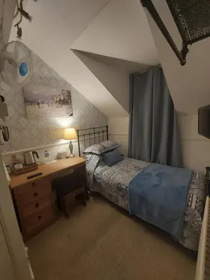 a bedroom with a bed and a desk with a lamp at Westfield House in Blackpool