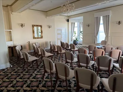 a room with a bunch of chairs and a mirror at The Savoy Hotel in Blackpool