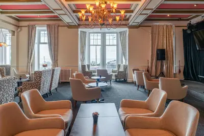 a waiting room with chairs and tables and a chandelier at The Savoy Hotel in Blackpool