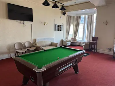 a living room with a pool table and a tv at The Savoy Hotel in Blackpool