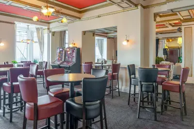 a restaurant with tables and chairs and a bar at The Savoy Hotel in Blackpool
