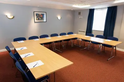 a conference room with wooden tables and chairs at Knowsley Inn & Lounge in Knowsley