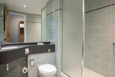 a bathroom with a toilet and a sink and a shower at Knowsley Inn & Lounge in Knowsley